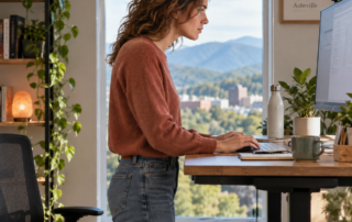 Desk worker at a standing desk with the head positioned forward of the shoulders, Asheville, NC.